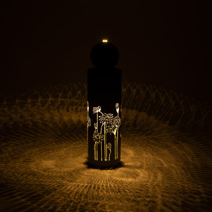 gilded vine cutout fountain glowing at night with illuminated pattern