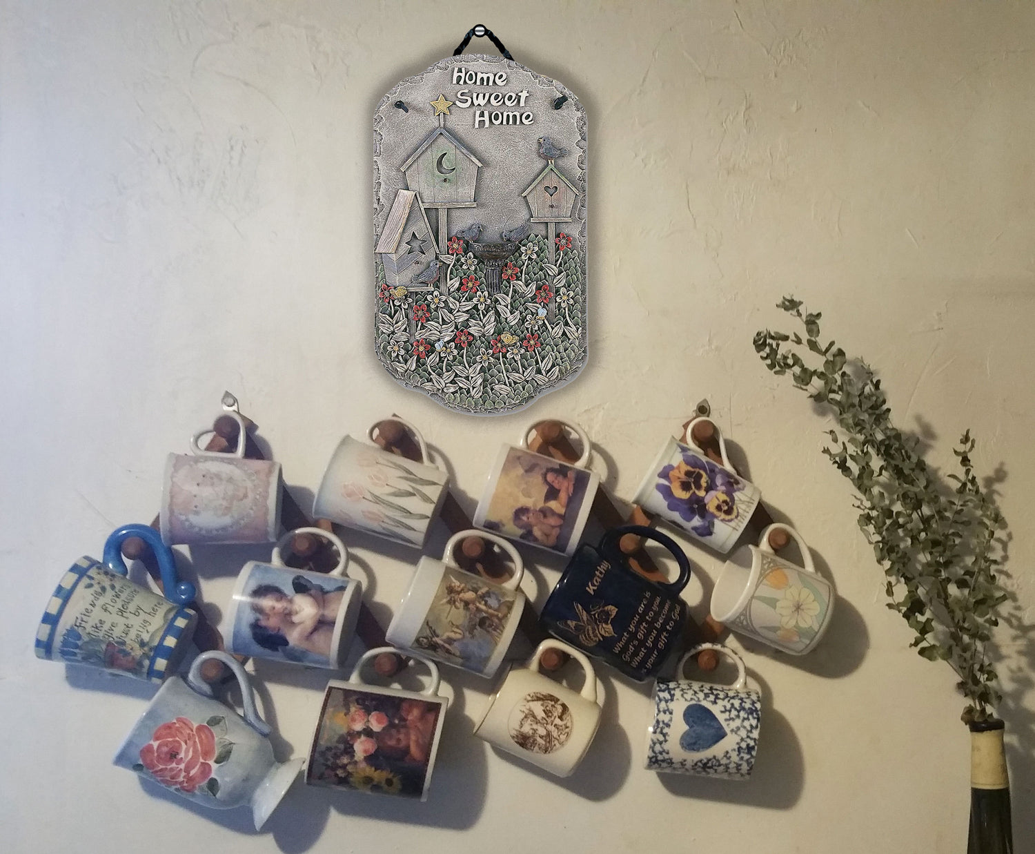 home sweet home birdhouse plaque hanging on a wall among garden decor plaques