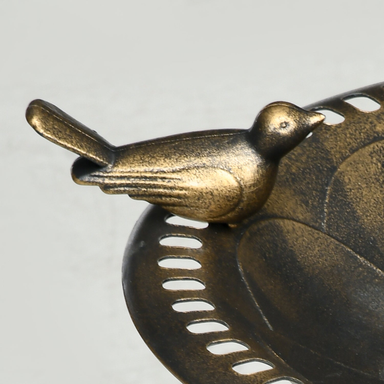 sculpted songbird and flower relief basin detail on antique bronze bird bath