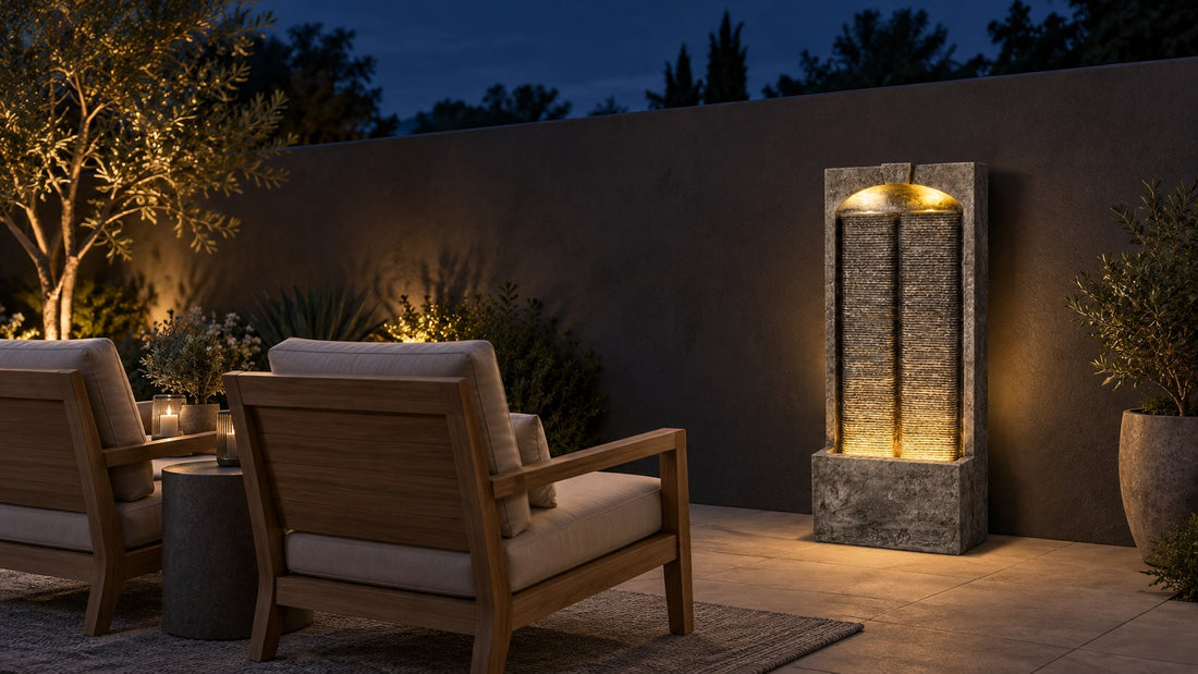 Split slate wall fountain glowing from its arched cap at night against a dark courtyard wall