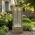 split sandstone column fountain in a garden with hydrangeas along a stone path