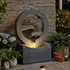 zen ring cascade fountain glowing warm on a patio against a stacked stone wall