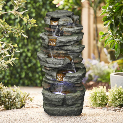 32.6"H simulation slate stone fountain adding a refreshing oasis feel to a sandy outdoor garden.
