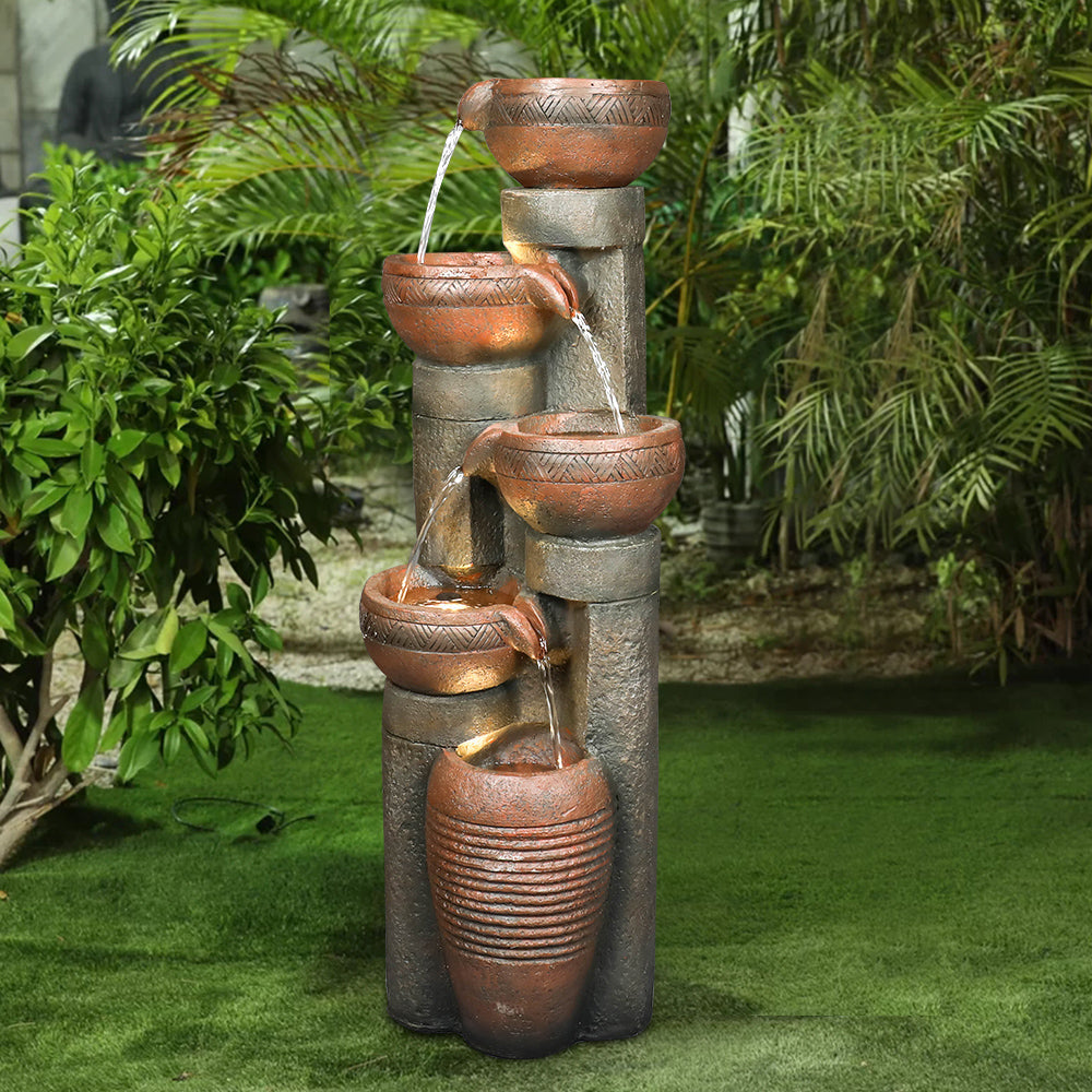 39.7 inch tall modern cascading column fountain placed in a decorative garden