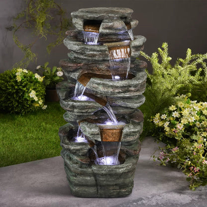 48"H 7-tier stacked shale outdoor fountain creating a peaceful focal point in a lush garden corner.