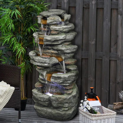 6-tier slate stone rock tower fountain tucked perfectly into a relaxing backyard fence corner.