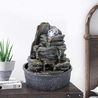 9.8"H resin rock tabletop fountain with spinning glass ball on a modern office desk
