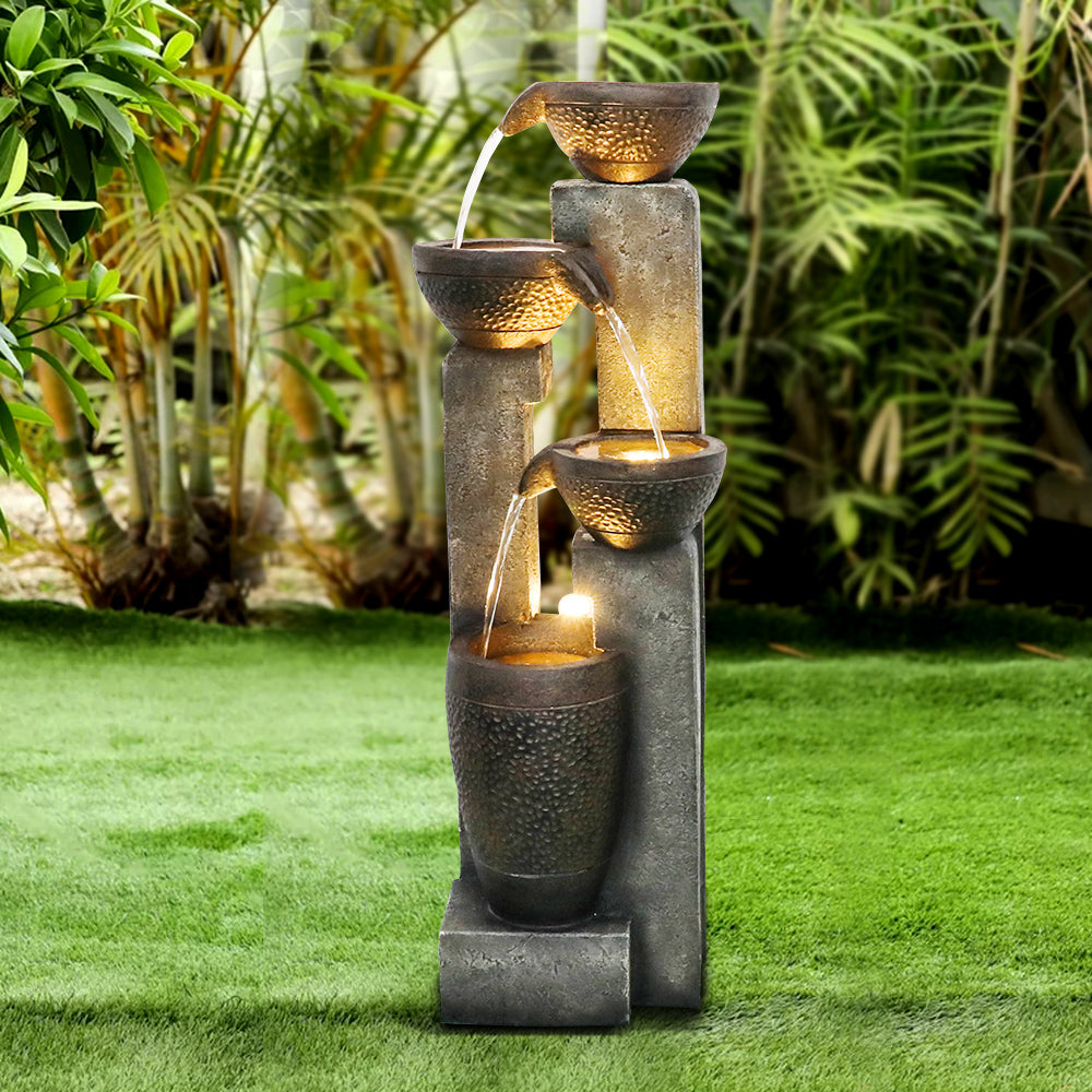 Cascading pot water feature standing elegantly on a fresh green lawn
