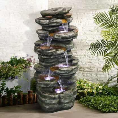Cascading rock waterfall fountain creating a relaxing oasis in a backyard patio