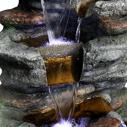Close-up of soothing water trickling down the mossy secondary tiers of the rock fountain.