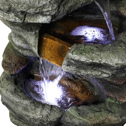 Close-up of the illuminated bottom basin capturing the cascading water of the slate fountain.