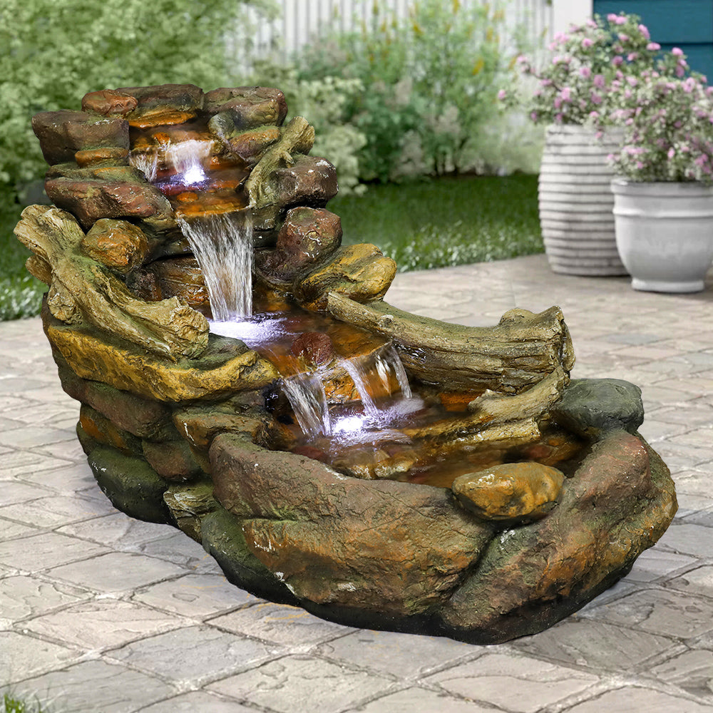 Horizontal river style waterfall fountain creating a natural border on a backyard patio