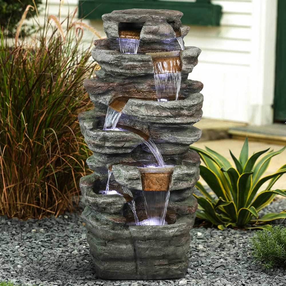 Large natural rockery cascading waterfall bringing tranquility to an outdoor blooming garden