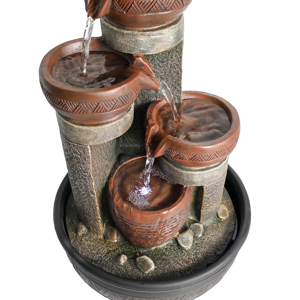 Macro view focusing on the lower tiers of the active fountain, showing cascading water, LED lights, and basin ripples.