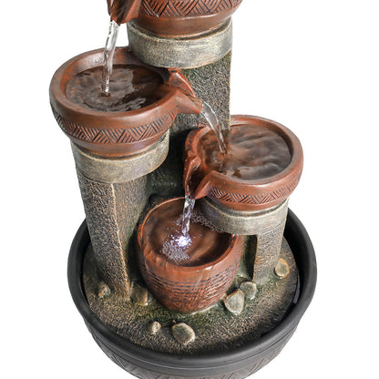 Macro view focusing on the lower tiers of the active fountain, showing cascading water, LED lights, and basin ripples.