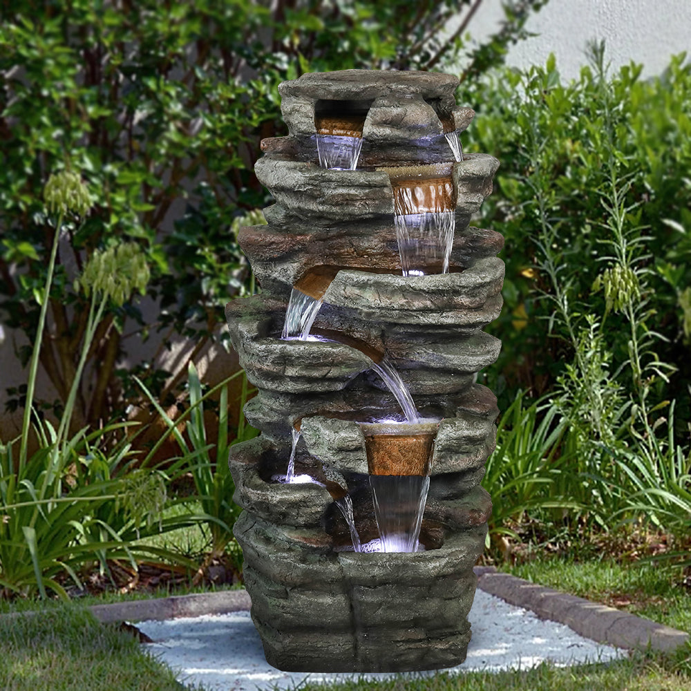 Majestic 48"H 7-tier stacked shale outdoor fountain acting as a focal point on a green lawn