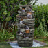 Majestic 48"H 7-tier stacked shale outdoor fountain acting as a focal point on a green lawn