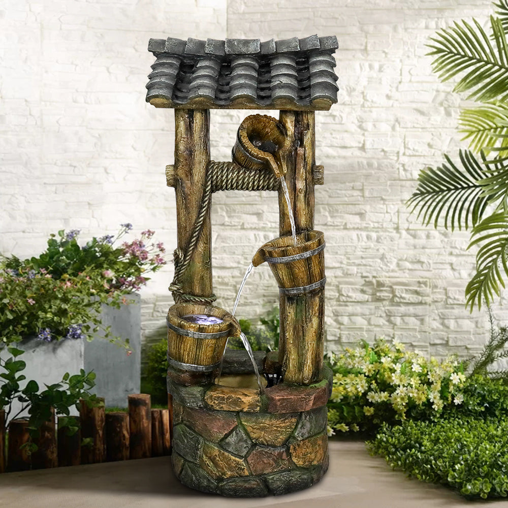 Old-fashioned wishing well fountain with LED lights creating a cozy night in the backyard