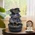 Realistic moss-coated rock indoor waterfall decorating a living room side table