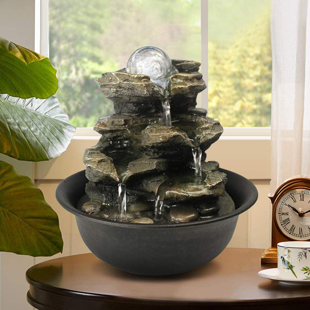 Small 4-tier realistic rock cascading fountain decorating a living room side table