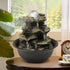 Small 4-tier realistic rock cascading fountain decorating a living room side table